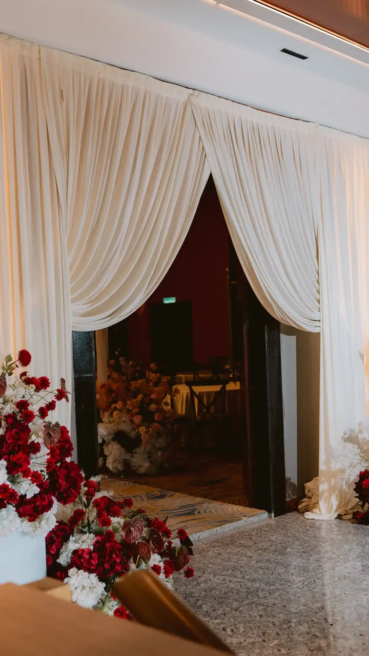 Draped entrance with red and white floral styling