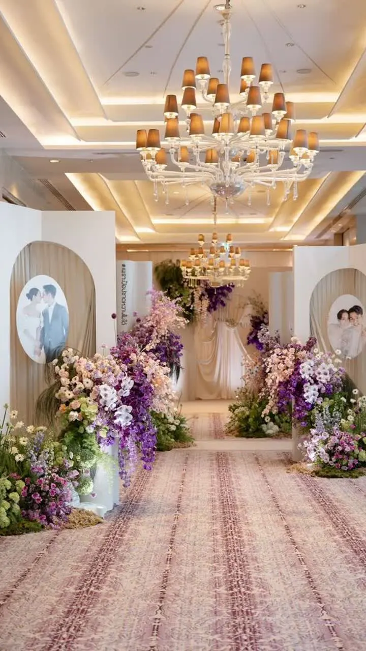 Floral wedding stage and chandelier-lit aisle