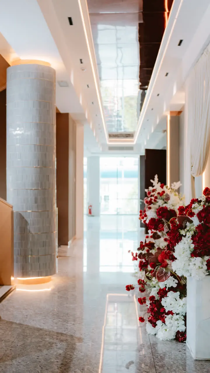 Venue corridor with red and white floral arrangement