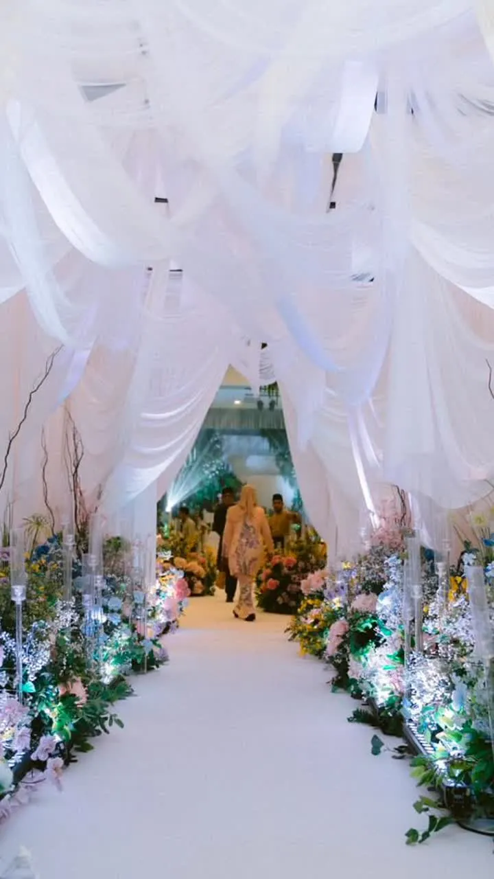 White draped ceremony walkway with floral lighting
